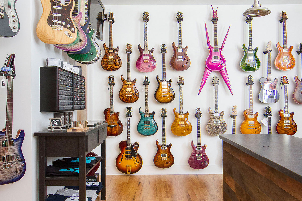A wall of electric guitars in browns, blues, and pinks.