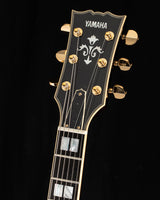 Yamaha SA2200-OVS Semi-Hollow guitar headstock, Violin Sunburst color, gold tuning pegs, ornate inlay design on black background.